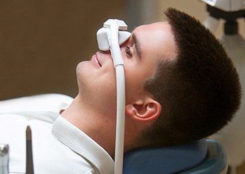 Patient relaxing while breathing in nitrous oxide in treatment chair