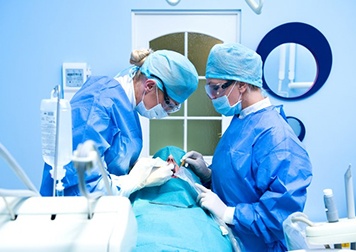 an oral surgeon performing dental implant placement surgery