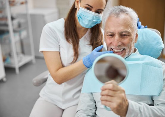 Patient admires his new smile with dentist standing next to him