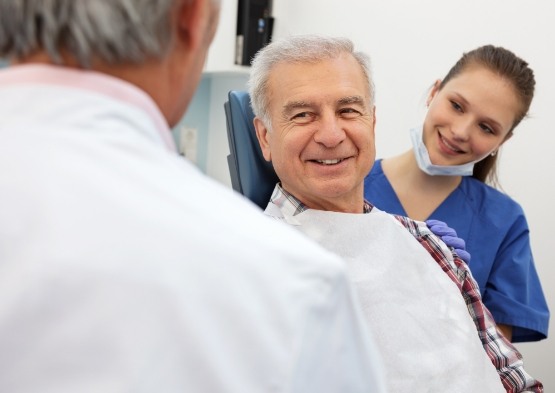 Periodontist explaining the four step dental implant process to dental patient