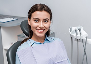 Female patient sitting in treatment chair and smiling