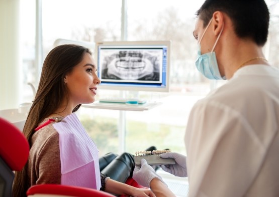 Woman smiling at periodontist after full mouth reconstruction