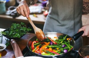 Person cooking vegetables in a pan